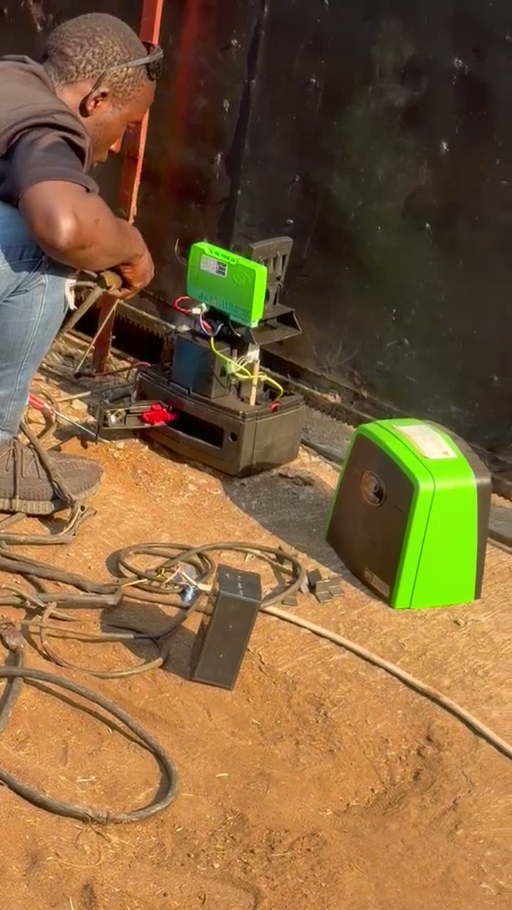 Technician installing a gate motor and rack on a steel gate